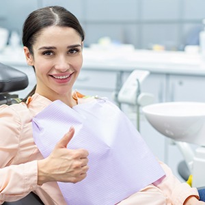 Female oral surgery patient giving a thumbs up