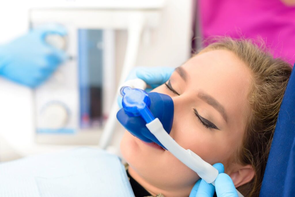 A woman undergoing a dental procedure wearing a nitrous oxide mask.